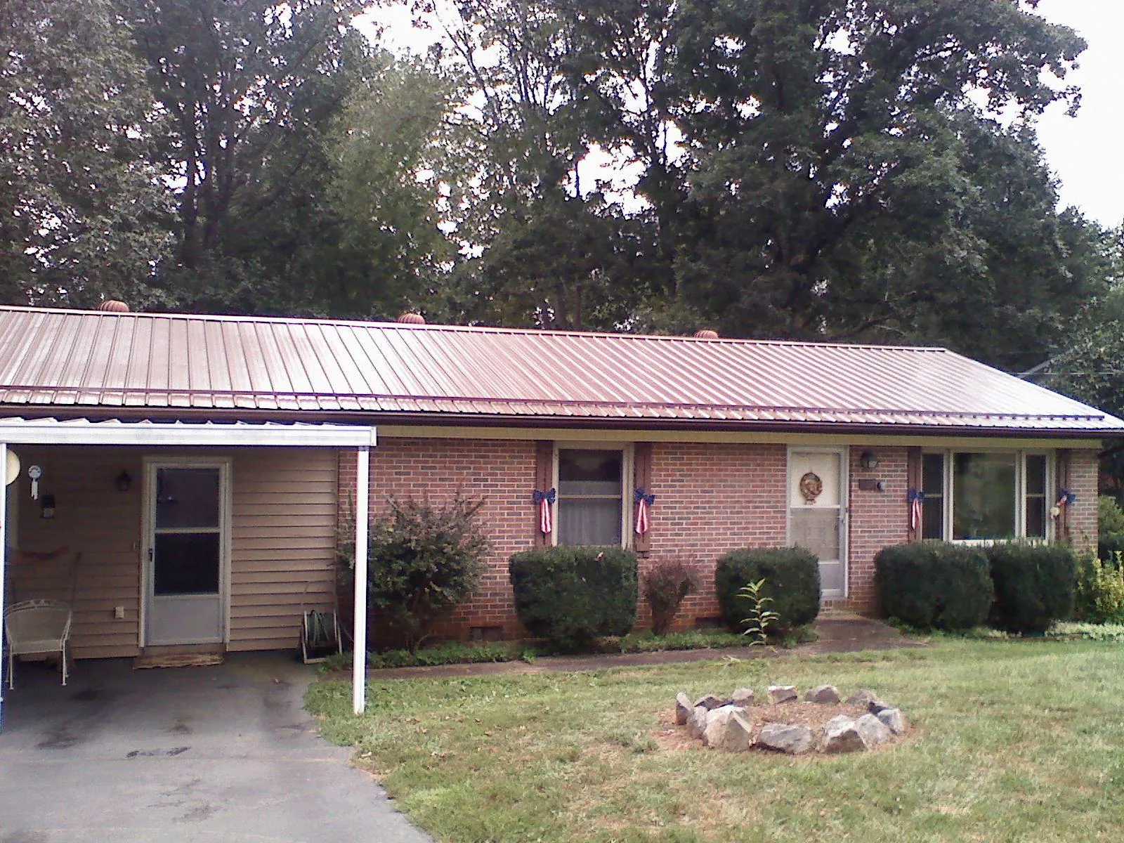 Bronze metal roof and carport on a brick ranch home — Roof Repair work by our crew in Texarkana