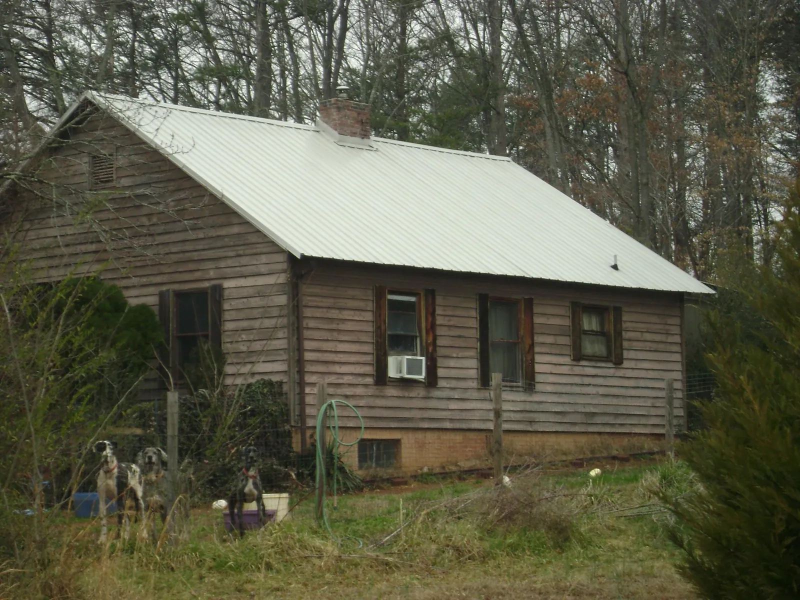 White metal roof on an old wood sided farmhouse, from a Metal Roof Installation job in Texarkana